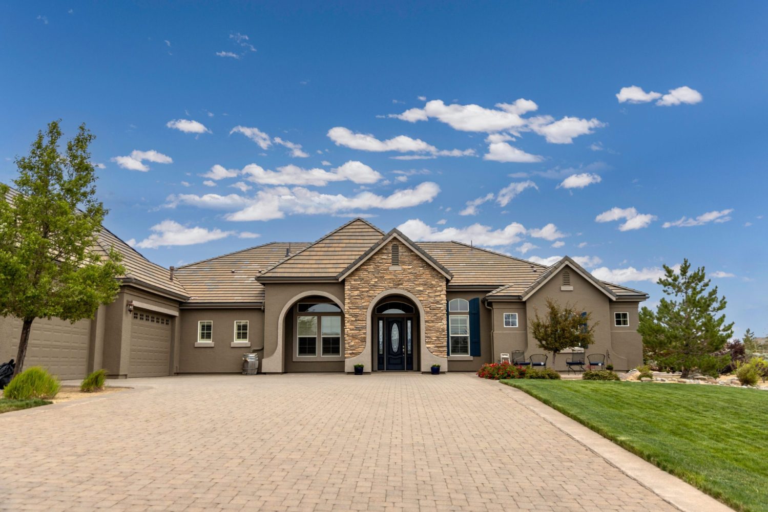 Modern house with large driveway and lawn.