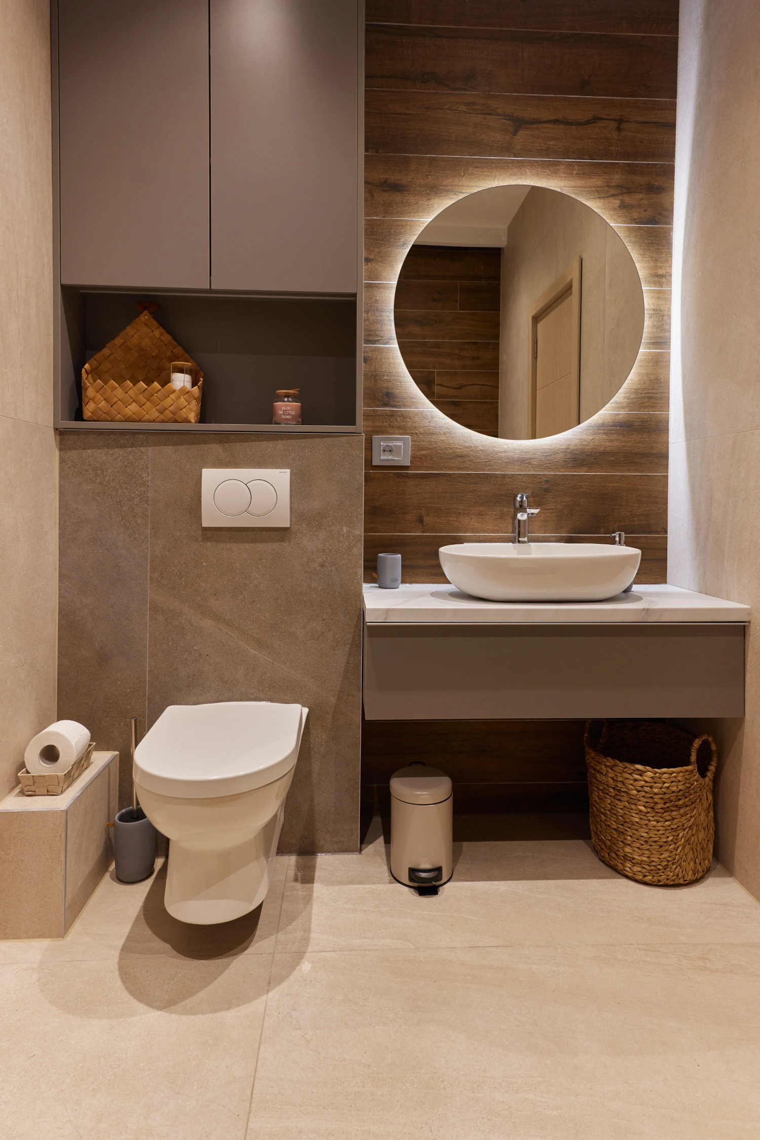 Modern bathroom with round mirror and sink.