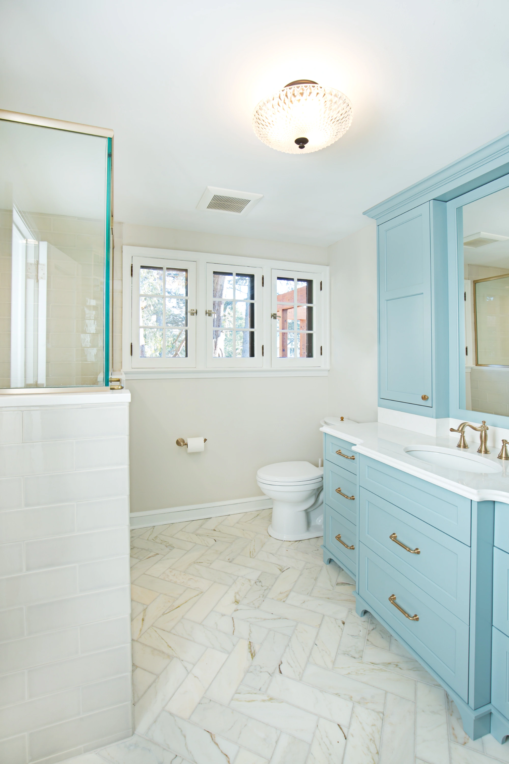 Bright bathroom with blue vanity and window.