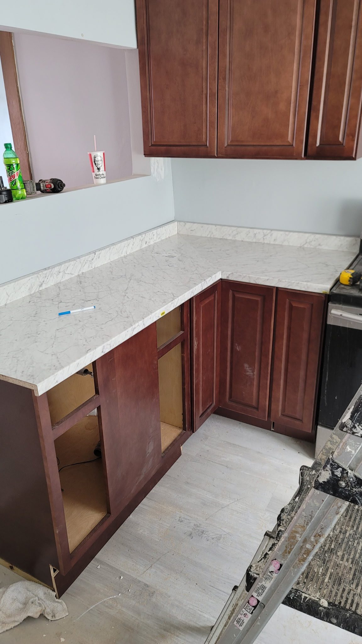 Kitchen renovation with marble countertop and cabinets.