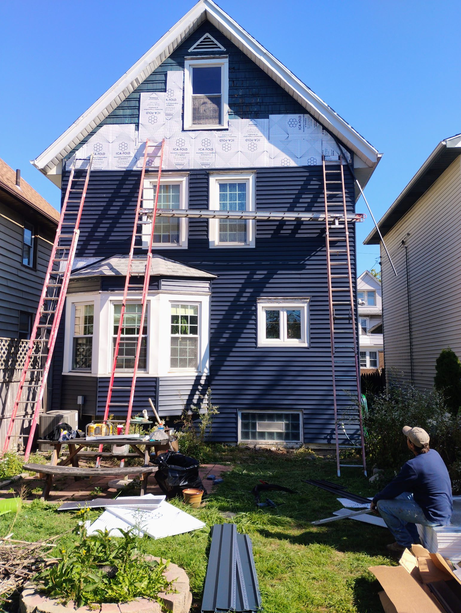 House exterior renovation with ladders and tools.