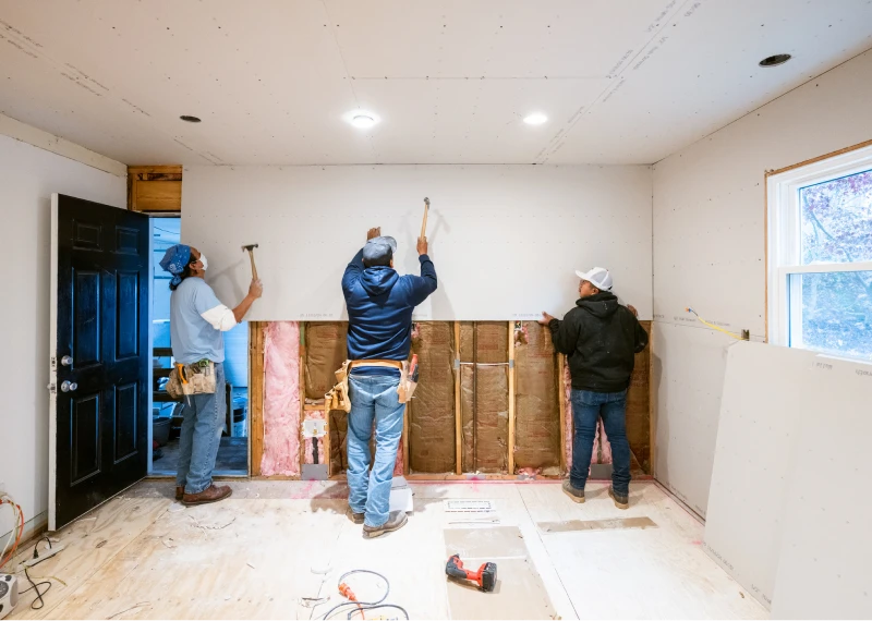 Construction workers installing drywall